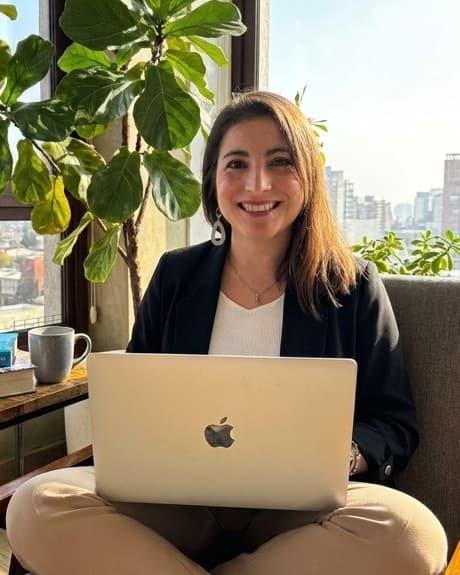 Lilian Valdebenito, psicóloga, sentada junto a una ventana con su computador
